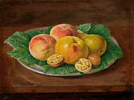 Opstilling med ferskner og valnødder på et fad med grønne blade 